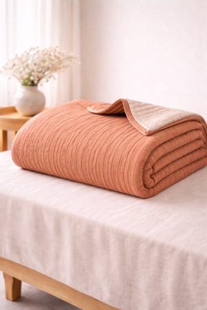 Terracotta cotton quilt with fine stitched detailing and soft breathable fabric in portrait style